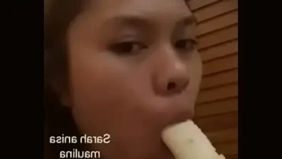 Asian girl sucking banana for fun